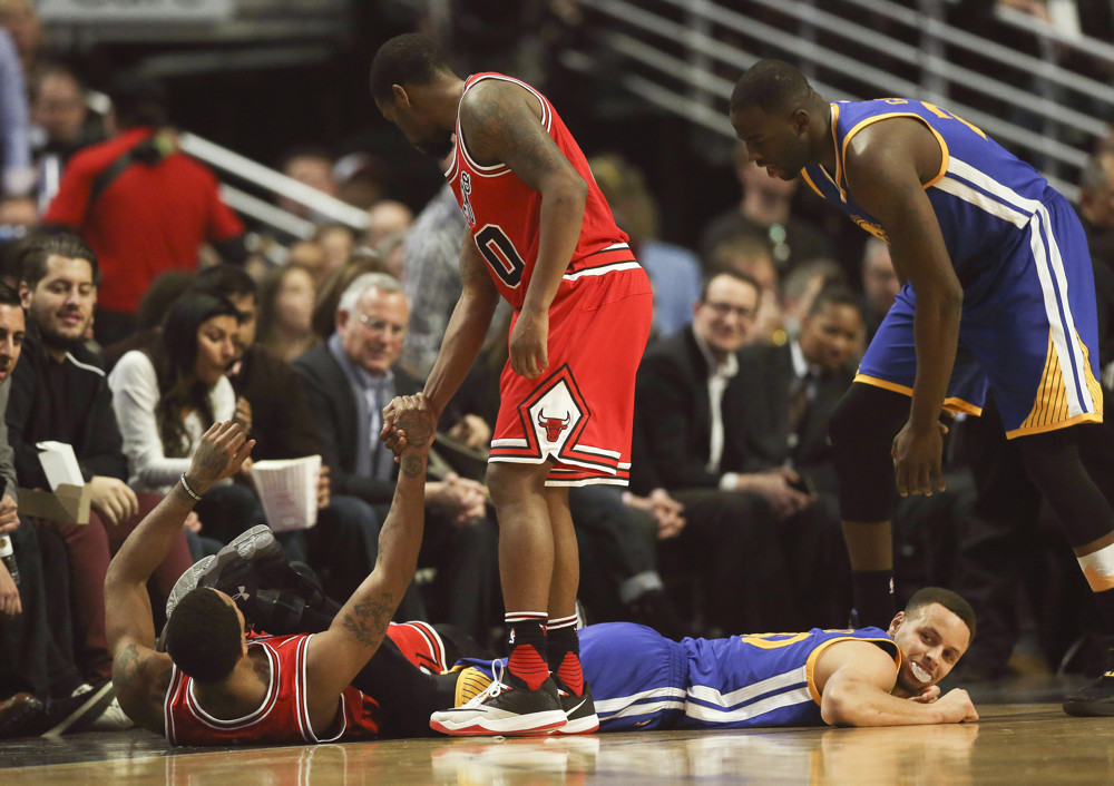 Jan. 20, 2016 - Chicago, IL, USA - The Chicago Bulls' Derrick Rose is helped up by teammate Aaron Brooks (0) after he fouled the Golden State Warriors' Stephen Curry, bottom right, during the first half at the United Center in Chicago on Wednesday, Jan. 20, 2016. The Warriors won, 125-94 (Photo by Nuccio Dinuzzo/Zuma Press/Icon Sportswire)
