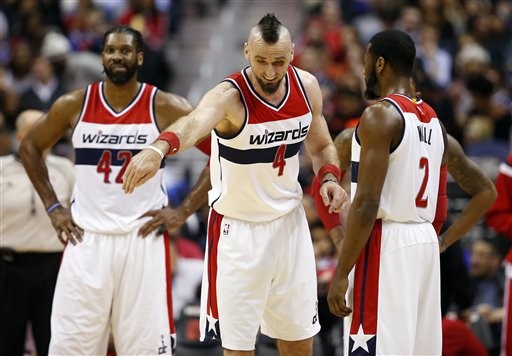 Washington Wizards forward Nene (42), from Brazil, stands as center Marcin Gortat (4), from Poland, talks with guard John Wall (2) in the second half of an NBA basketball game against the New York Knicks, Wednesday, Jan. 7, 2015, in Washington. The Wizards won 101-91.(AP Photo/Alex Brandon)