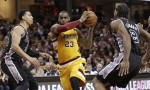 Cleveland Cavaliers' LeBron James, center, drives between San Antonio Spurs' Danny Green, left, and Kawhi Leonard during the second half of an NBA basketball game Saturday, Jan. 30, 2016, in Cleveland. The Cavaliers won 117-103. (AP Photo/Tony Dejak)