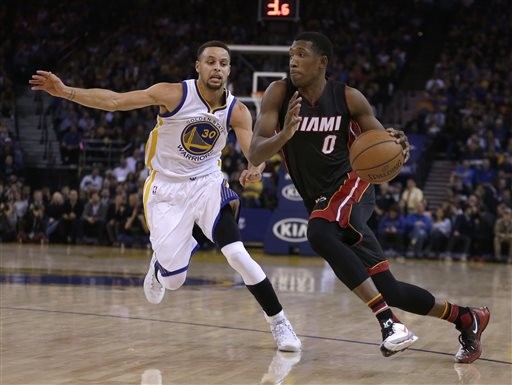 Miami Heat guard Josh Richardson, right, drives the ball against Golden State Warriors' Stephen Curry (30) during the first half of an NBA basketball game, Monday, Jan. 11, 2016, in Oakland, Calif. (AP Photo/Ben Margot)