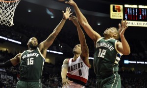 Feb 2, 2016; Portland, OR, USA; Portland Trail Blazers guard Damian Lillard (0) drives to the basket on Milwaukee Bucks center Greg Monroe (15) and forward Jabari Parker (12) during the third quarter of the game at the Moda Center at the Rose Quarter. Blazers won 107-95. Mandatory Credit: Steve Dykes-USA TODAY Sports