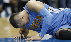 Denver Nuggets forward Danilo Gallinari is slow to get off the floor as the Nuggets take on the Dallas Mavericks during the second half of an NBA basketball game, Friday, Feb. 26, 2016, in Dallas. (AP Photo/Ron Jenkins)