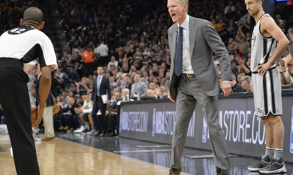 Golden State Warriors head coach Steve Kerr, center, yells at referee Eric Lewis (42) as San Antonio Spurs guard Manu Ginobili, of Argentina, looks on during the first half of an NBA basketball game, Saturday, March 19, 2016, in San Antonio. Kerr was called for a technical foul. San Antonio won 87-79. (AP Photo/Darren Abate)