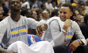 Golden State Warriors forward Harrison Barnes, left, makes guard Stephen Curry laugh on the bench during the second half of an NBA preseason basketball game against the Los Angeles Lakers in Anaheim, Calif., Thursday, Oct. 22, 2015. The Warriors won 136-97. (AP Photo/Alex Gallardo)