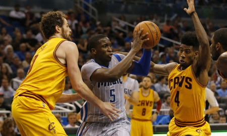 Orlando Magic guard Victor Oladipo (5) drives between the defense of Cleveland Cavaliers forward Kevin Love (0) and Cleveland Cavaliers guard Iman Shumpert (4)during the second half of an NBA basketball game, Friday, March 18, 2016, in Orlando, Fla. The Cleveland Cavaliers defeated the Orlando Magic, 109-103. (AP Photo/Scott Audette)
