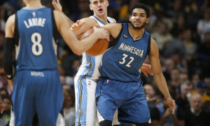 Minnesota Timberwolves guard Zach LaVine (8), front, looks to pass the ball as Minnesota Timberwolves center Karl-Anthony Towns (32), back right, battles for position with Denver Nuggets center Nikola Jokic (15) in the second half of an NBA basketball game Friday, Dec.11, 2015, in Denver. Denver won 111-108 in overtime. (AP Photo/David Zalubowski)