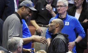 Former NBA player David Robinson, left, talks with Los Angels Laker Kobe Bryant as Tim Cook, CEO of Apple looks on during the second half of an NCAA college basketball game between Oregon and Duke in the regional semifinals of the NCAA Tournament, Thursday, March 24, 2016, in Anaheim, Calif. (AP Photo/Mark J. Terrill)