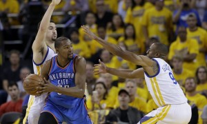 Oklahoma City Thunder forward Kevin Durant, center, is guarded by Golden State Warriors guard Klay Thompson, rear, and forward Andre Iguodala (9) during the second half of Game 2 of the NBA basketball Western Conference finals in Oakland, Calif., Wednesday, May 18, 2016. The Warriors won 118-91. (AP Photo/Marcio Jose Sanchez)